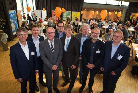 Referenten der Zukunftskonferent „kreispb25“ (von links): Uwe Borchers, Marcel Frischkorn (beide Zentrum für Innovation in der Gesundheitswirtschaft OWL gGmbH – ZIG, Bielefeld), Landrat Manfred Müller, Matthias Toups (Zukunftsnetz Mobilität NRW, Paderborn), Prof. Dr. Nikolaus Risch (ehemaliger Präsident der Universität Paderborn), Wilfried Lohre (Netzwerk Kommunale Bildung), Dr. Christoph Berse (Landesweite Koordinierungsstelle Kommunale Integrationszentren, Dortmund), Peter Kaiser (Prognos AG). (Foto: Oliver Krato) Gruppenfoto Referenten, Publikum im Hintergrund